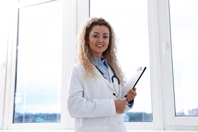 Photo of Portrait of professional pediatrician with stethoscope and clipboard in hospital