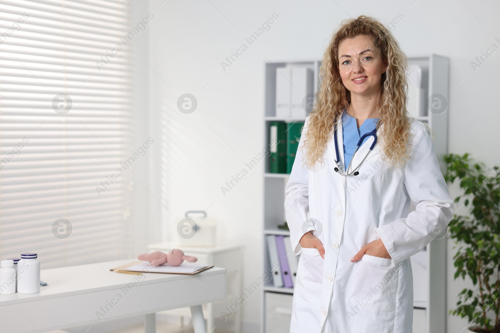 Portrait of professional pediatrician with stethoscope in hospital. Space for text Photo of Portrait of professional pediatrician with stethoscope in hospital. Space for text