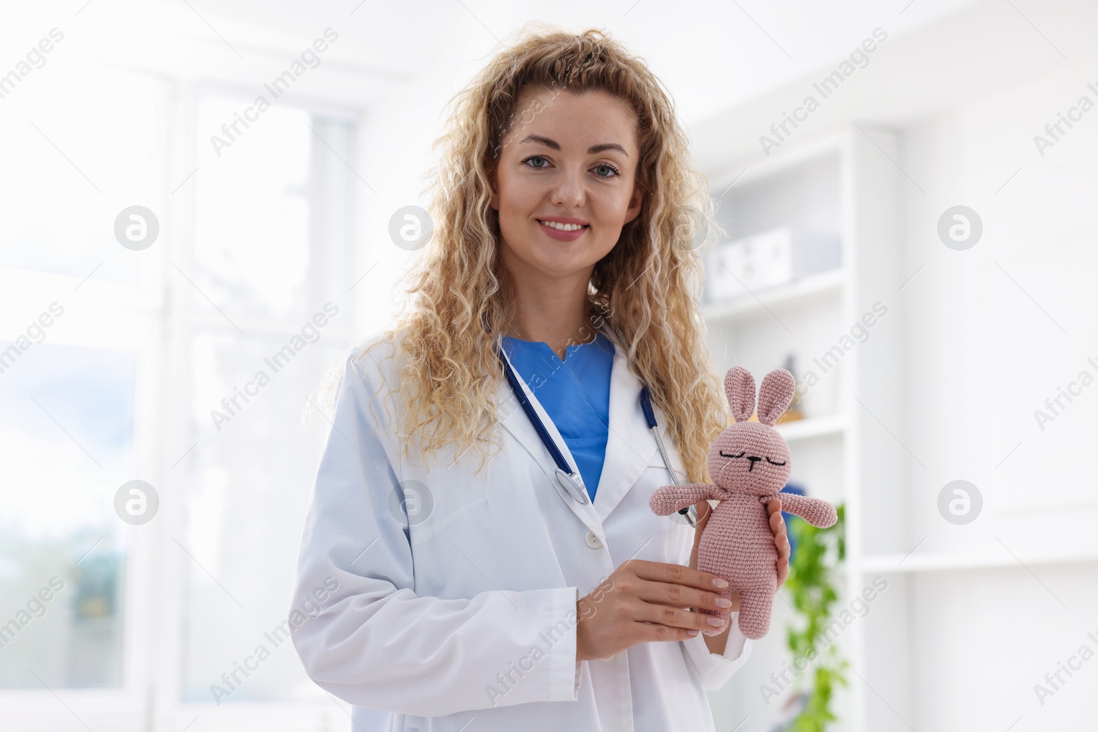 Professional pediatrician with toy bunny in hospital Photo of Professional pediatrician with toy bunny in hospital