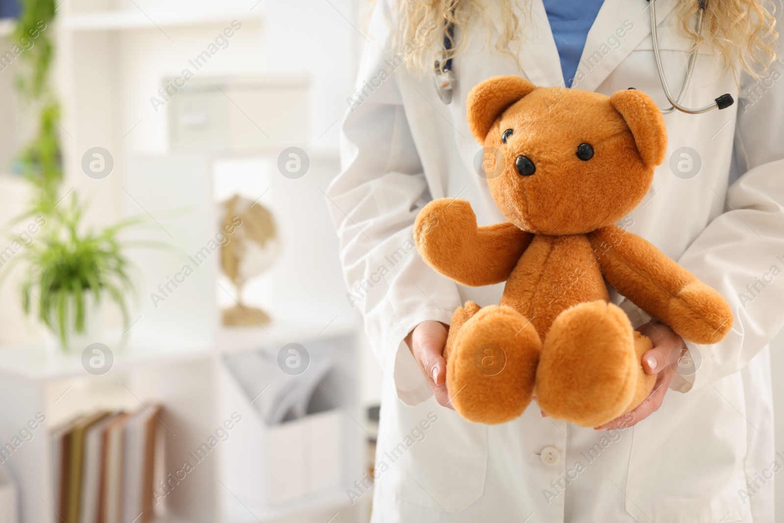 Pediatrician with toy bear in hospital, closeup. Space for text Photo of Pediatrician with toy bear in hospital, closeup. Space for text