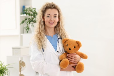Photo of Professional pediatrician with toy bear in hospital