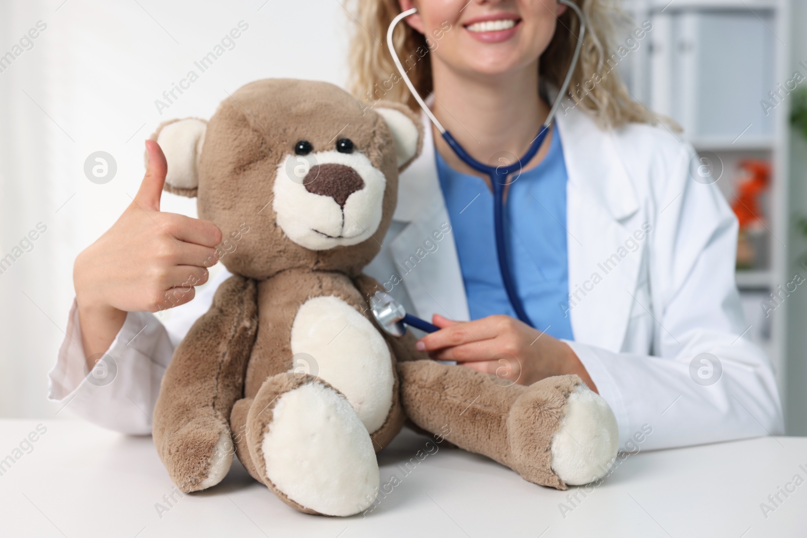 Pediatrician checking heartbeat of toy bear at desk in hospital, closeup Photo of Pediatrician checking heartbeat of toy bear at desk in hospital, closeup
