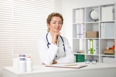 Photo of Professional pediatrician working at desk in clinic