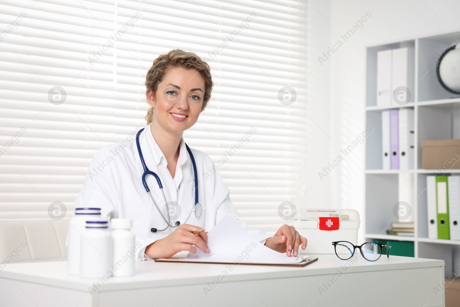 Professional pediatrician working at desk in clinic Photo of Professional pediatrician working at desk in clinic