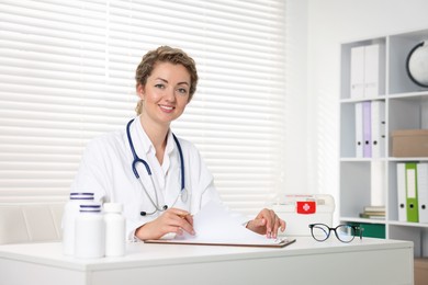 Photo of Professional pediatrician working at desk in clinic