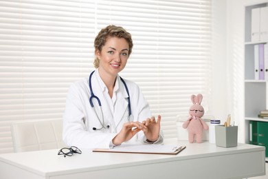 Photo of Professional pediatrician working at desk in clinic