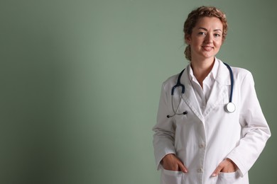 Photo of Portrait of professional pediatrician with stethoscope on olive background. Space for text