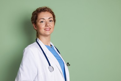 Photo of Portrait of professional pediatrician with stethoscope on olive background. Space for text