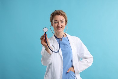 Photo of Portrait of professional pediatrician with stethoscope on light blue background