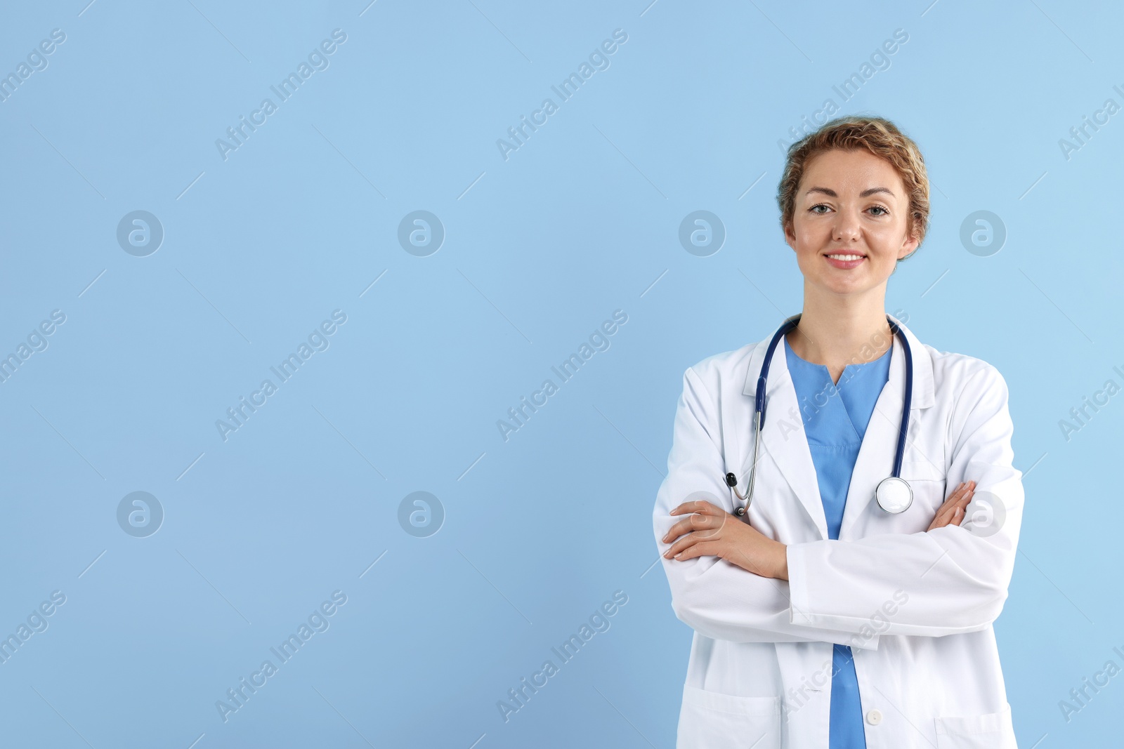 Portrait of professional pediatrician with stethoscope on light blue background. Space for text Photo of Portrait of professional pediatrician with stethoscope on light blue background. Space for text