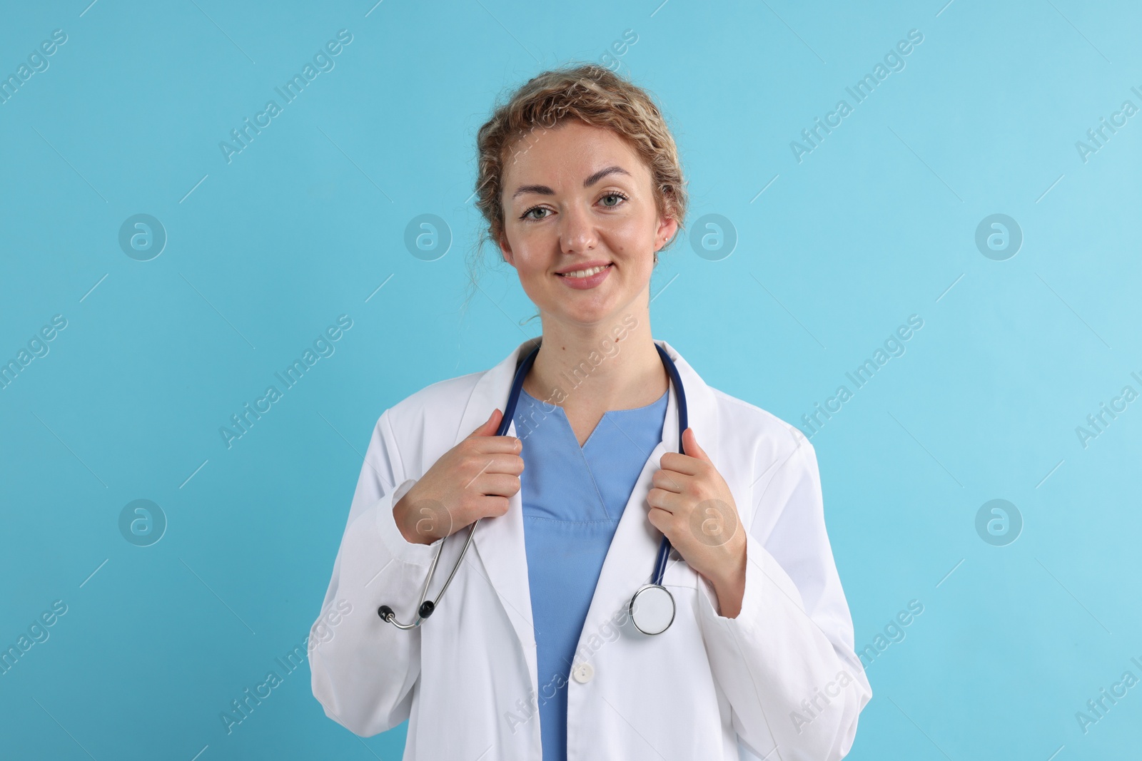 Portrait of professional pediatrician with stethoscope on light blue background Photo of Portrait of professional pediatrician with stethoscope on light blue background