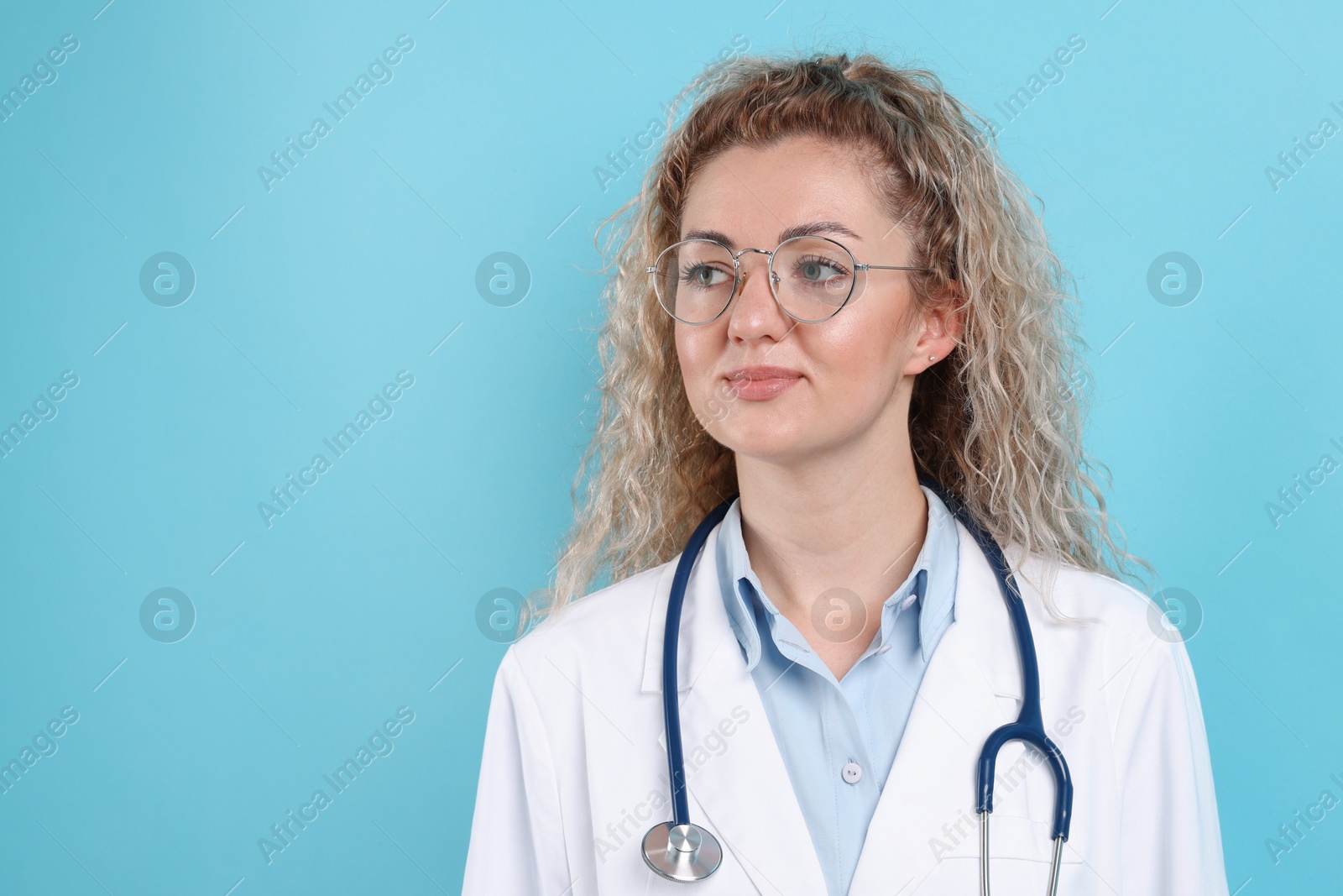 Pediatrician with stethoscope on light blue background. Space for text Photo of Pediatrician with stethoscope on light blue background. Space for text