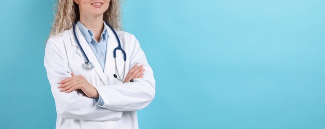 Photo of Pediatrician on light blue background, closeup. Space for text