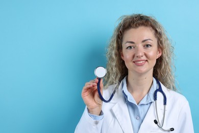 Photo of Pediatrician with stethoscope on light blue background. Space for text
