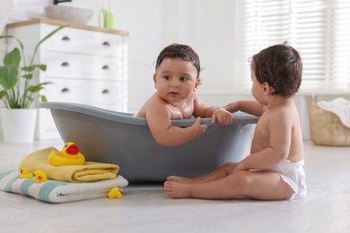 Photo of Cute little twin brothers bathing at home