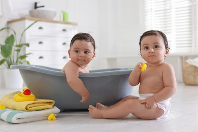 Photo of Cute little twin brothers bathing at home