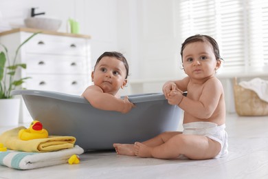 Photo of Cute little twin brothers bathing at home