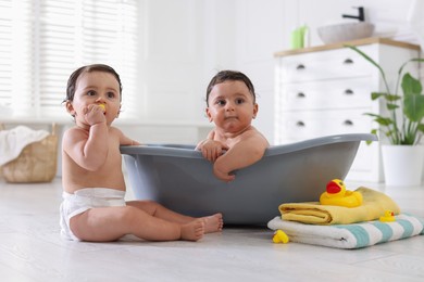Photo of Cute little twin brothers bathing at home