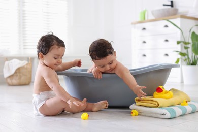 Photo of Cute little twin brothers bathing at home