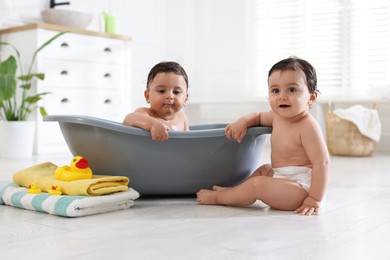 Photo of Cute little twin brothers bathing at home