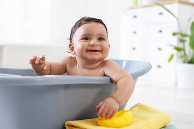 Photo of Cute little baby bathing in tub at home