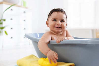 Photo of Cute little baby bathing in tub at home