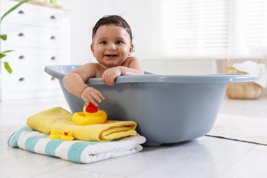 Photo of Cute little baby bathing in tub at home