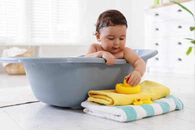 Photo of Cute little baby bathing in tub at home