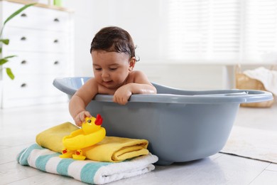 Photo of Cute little baby bathing in tub at home
