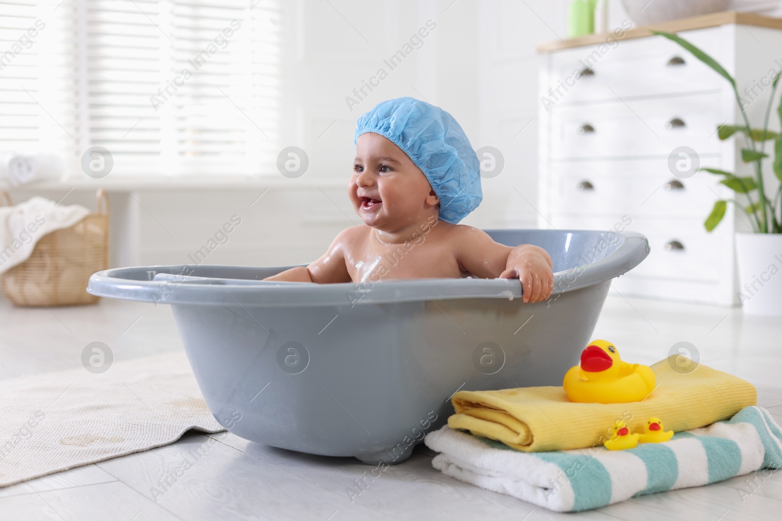 Cute little baby in cap bathing at home Photo of Cute little baby in cap bathing at home