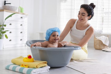 Photo of Mom giving bath to her little baby at home