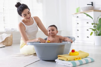 Photo of Mom giving bath to her little baby at home
