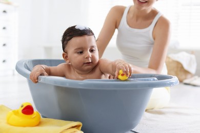 Photo of Mom bathing her little baby at home, closeup