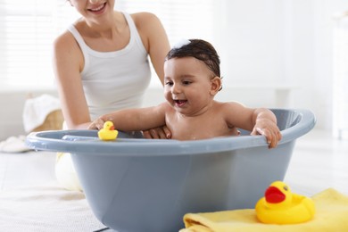 Photo of Mom bathing her little baby at home, closeup