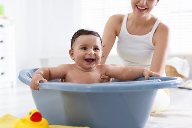Photo of Mom bathing her little baby at home, closeup