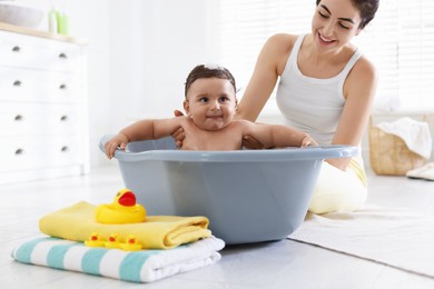 Photo of Mom bathing her little baby at home, closeup