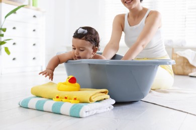Photo of Mom bathing her little baby at home, closeup