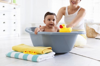 Photo of Mom bathing her little baby at home, closeup