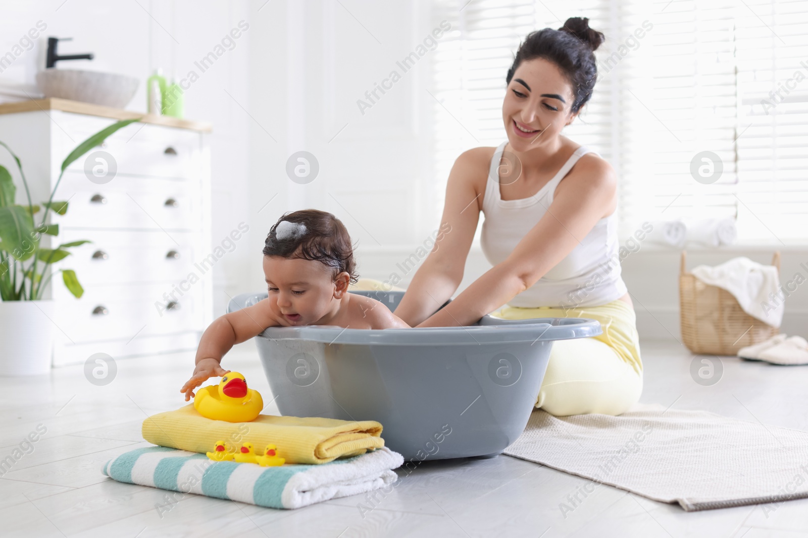 Mom giving bath to her little baby at home Photo of Mom giving bath to her little baby at home