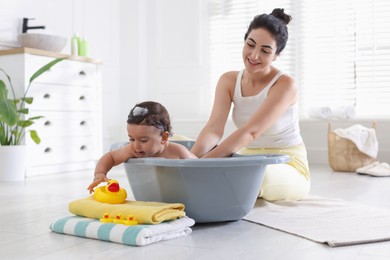 Photo of Mom giving bath to her little baby at home