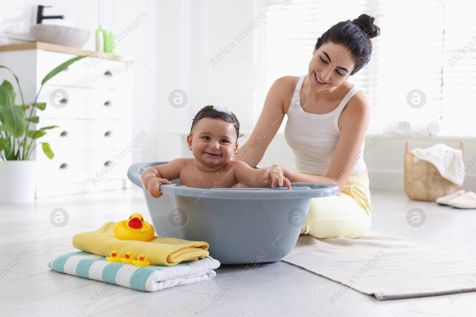 Mom giving bath to her little baby at home Photo of Mom giving bath to her little baby at home