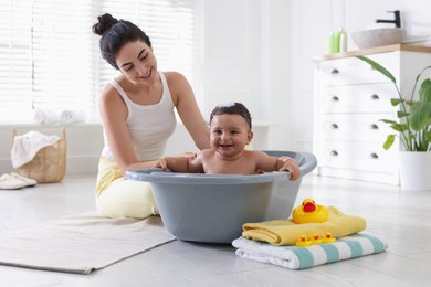 Photo of Mom giving bath to her little baby at home