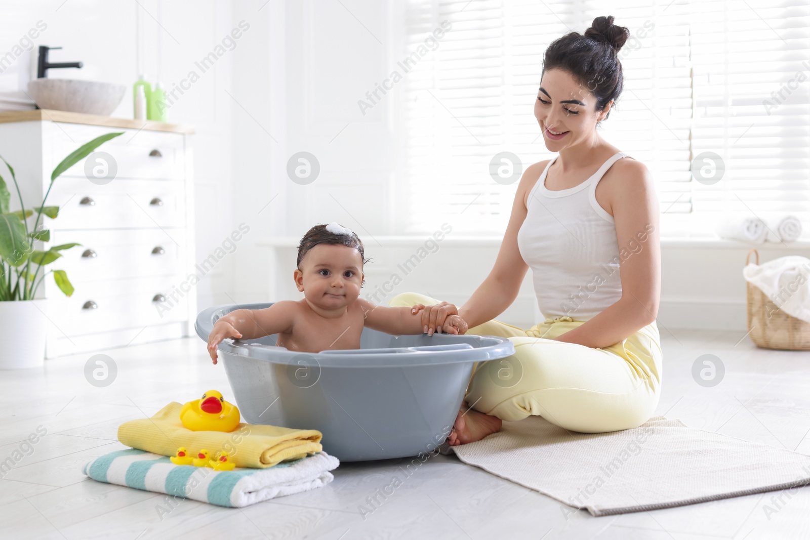 Mom giving bath to her little baby at home Photo of Mom giving bath to her little baby at home