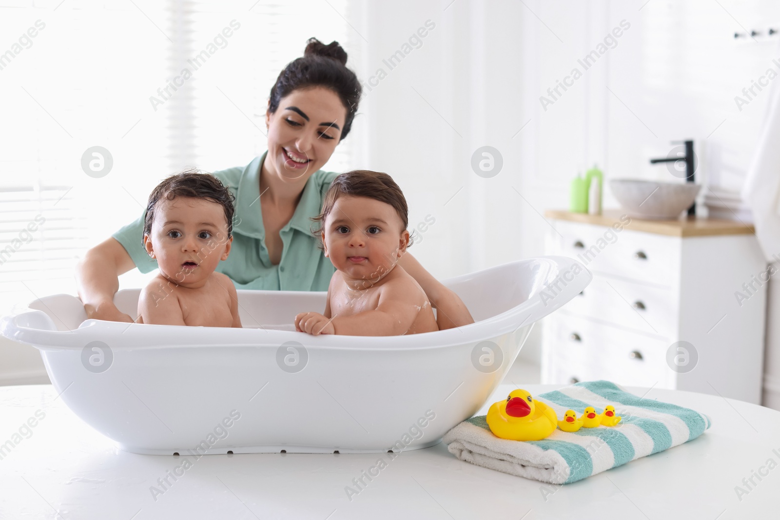 Mom bathing her twin children at home Photo of Mom bathing her twin children at home
