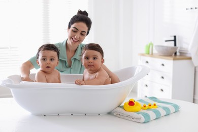 Photo of Mom bathing her twin children at home