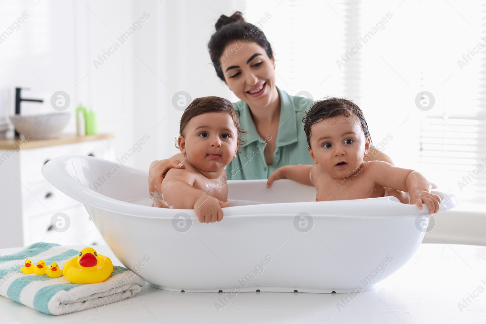 Mom bathing her twin children at home Photo of Mom bathing her twin children at home