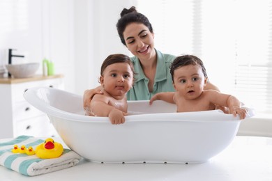 Photo of Mom bathing her twin children at home
