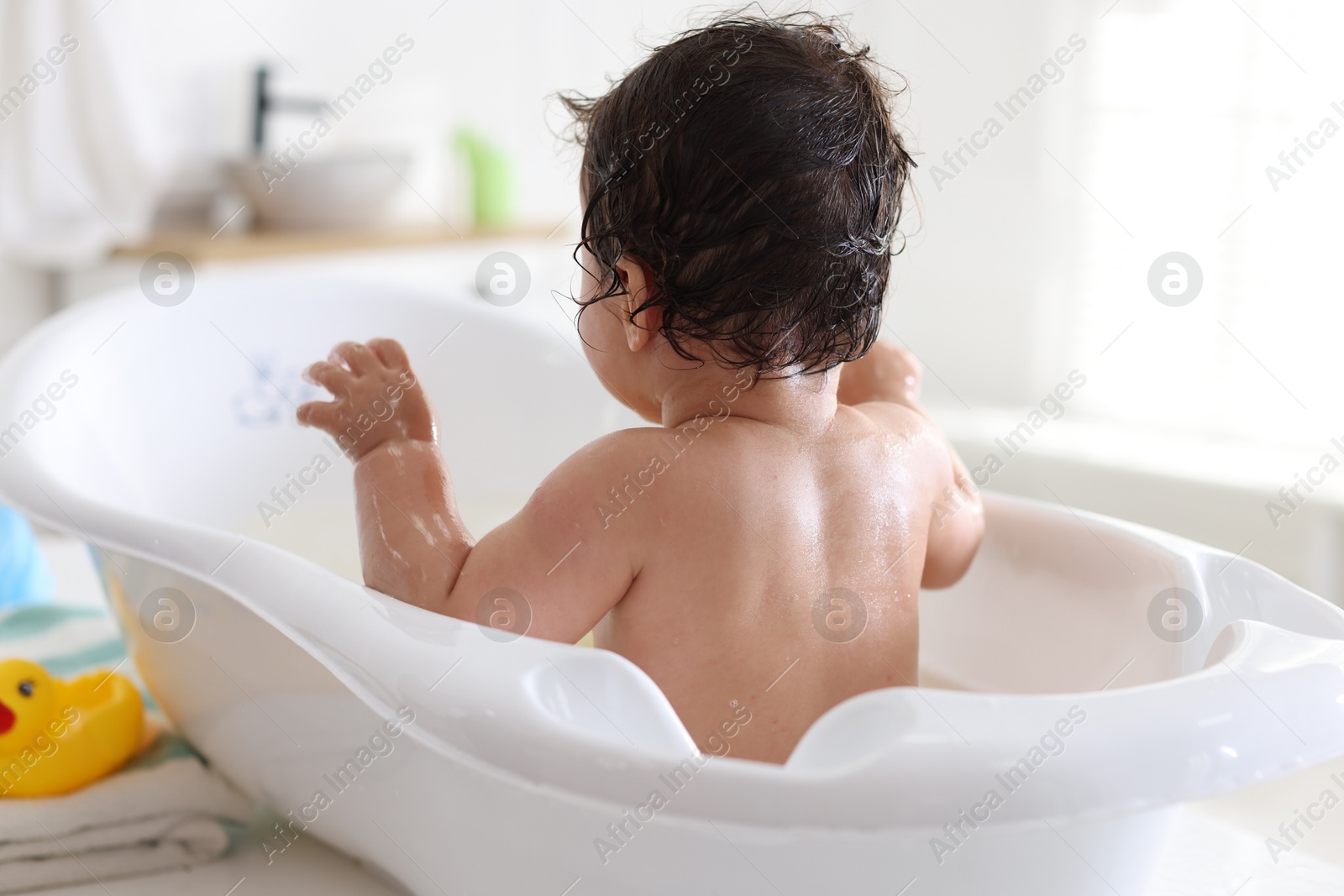 Cute little baby bathing at home, back view Photo of Cute little baby bathing at home, back view