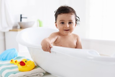 Photo of Cute little baby bathing in tub at home