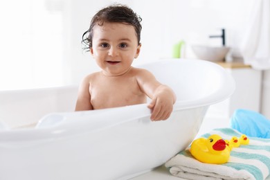Photo of Cute little baby bathing in tub at home